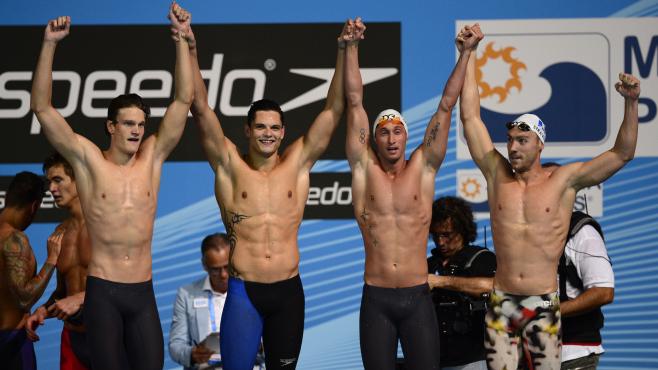 Yannick Agnel (à g.), Florent Manaudou, Fabien Gilot et Jérémy Stravius après leur victoire aux Mondiaux de natation à Barcelone (Espagne) sur le relais 4x100 m nage libre, dimanche 28 juillet 2013. (LLUIS GENE / AFP)